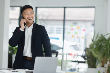 Portrait of candid happy asian businessman working in office.