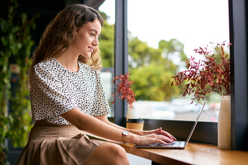 Young Businesswoman With Takeaway Coffee Working Sitting On Laptop In Coffee Shop Or Office