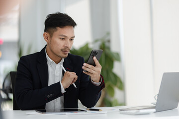 Portrait of candid happy asian businessman working in office.