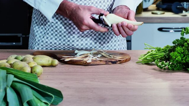 parsley root peeling on a wooden table vegetables healthy food, cook peeling vegetables, vegetarian cuisine, 4k video in front of the camera