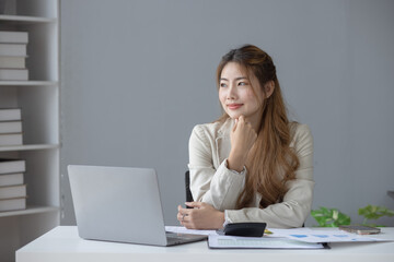 Smiling Asian businesswoman executive manager sitting at desk in office, Portrait of attractive professional asian businesswoman.