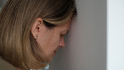 Desperate woman blunts against wall and worrying about problems at work. Employee is sad and faced difficulties