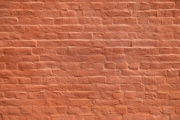 Texture of a brick wall coated with the thick layer of pastel orange paint as an architectural background