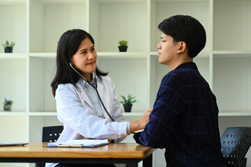 Female doctor using stethoscope, listening to male patient breath or heartbeat. Healthy care, medicine and insurance concept