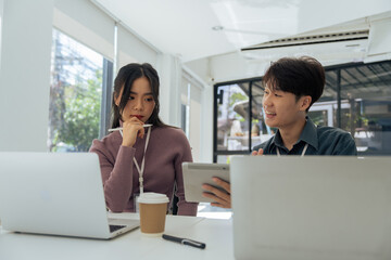Employees discuss brainstorming planning business strategy on laptop at desk together in the office