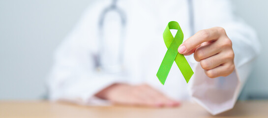Doctor with green Ribbon for world Lymphoma Awareness September month, world Mental Health Day, Liver, Gallbladders, bile duct, cervical, kidney Cancer. Healthcare and world cancer day concept