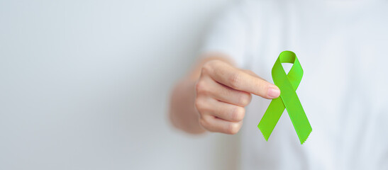 Woman holding green Ribbon for world Lymphoma Awareness September month, world Mental Health Day, Liver, Gallbladders, bile duct, cervical, kidney Cancer. Healthcare and world cancer day concept