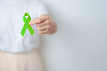 Woman holding green Ribbon for world Lymphoma Awareness September month, world Mental Health Day,...
