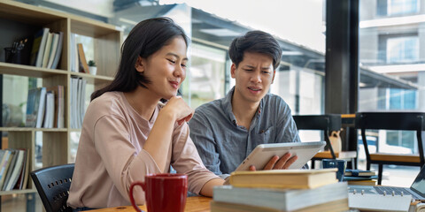 female and male studying together at the library