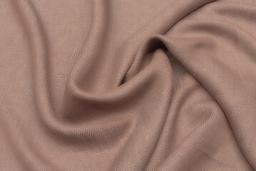 Close-up texture of natural beige fabric or cloth in brown color. Fabric texture of natural cotton or linen textile material. Beige canvas background.