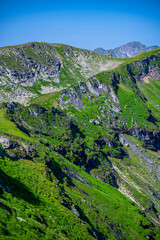 Fototapeta na wymiar Summer landscape of the Fagaras Mountains, Romania. A view from the hiking trail near the Balea Lake and the Transfagarasan Road.