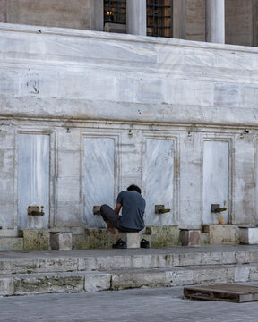 Istanbul, Turkey - 23 April 2023: View of devote persons washing the feet before the praying at Suleymaniye Mosque, Istanbul, Turkey.