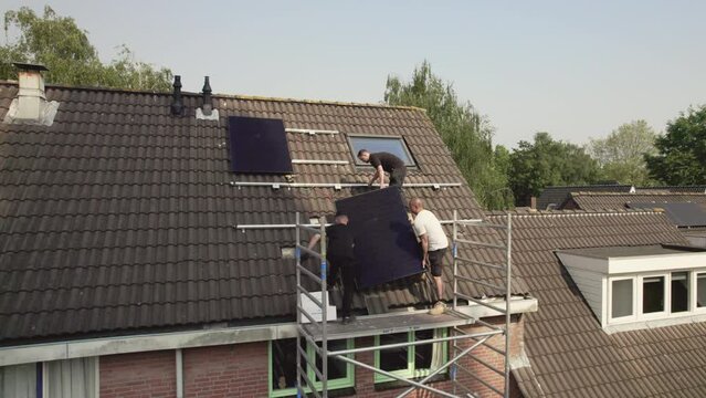 WS ZI Technicians fitting solar photo voltaic panels to house roof