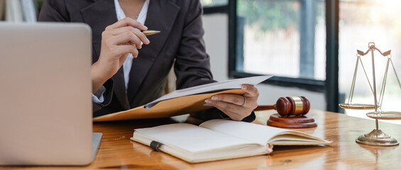 Young female lawyer asian people in real estate working law book and contract documents Arguments for Defense Strategy. Fight for Freedom. Supporting Evidence