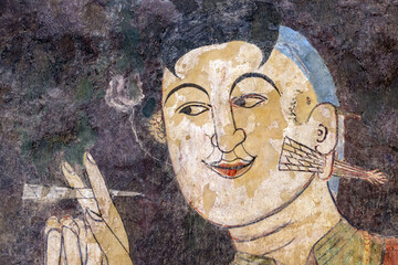 A man smokes a cigarette, mural painting from 19th century inside a Buddhist temple The Wat Phumin,...