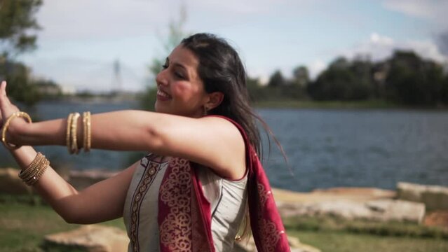 Attractive South Asian Female Tourist Dancing Classical Indian Music In The Park In Sydney, Australia. Slow Motion