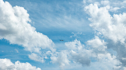 Commercial airplane between clouds. passaner plane flies on the sky framed by cumulus clouds.