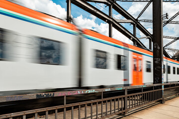 Local passenger train passes the railroad bridge. Frankfurt am Main, Germany in the afternoon,...