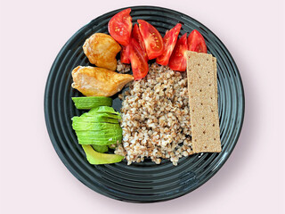 Top view of healthy food in a plate, boiled buckwheat with a boiled egg in a plate, appetizing zucchini with chopped tomato, with porridge in a plate