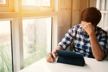 Asian man working with tablet under pressure and so stressful.