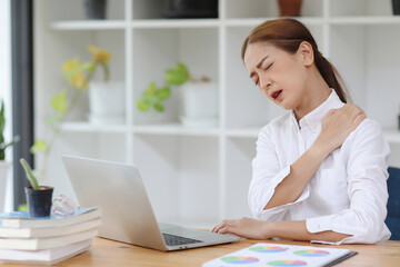 Asia woman suffering from neck pain in office. Young businesswoman suffer from shoulder pain from working too much.