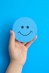 promoting positive mental health hand holding paper smiley. High quality photo
