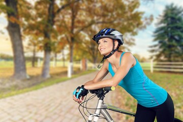 Naklejka premium Cyclist woman in a helmet at mountain background