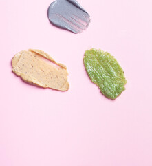 Set multicolored smears of scrub on a pink background. Texture of skin care cosmetic product.