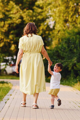 Child feels a mix of emotions as he looks back at his mom, unsure of what the future holds. The unhappy baby clings to his mother's hand, hoping that she can make everything better. Kid aged two years