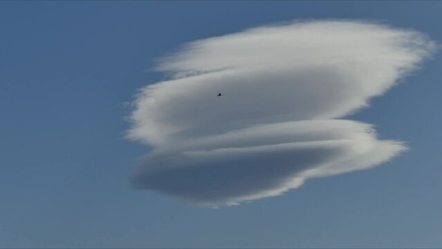 Blue sky with moving Lenticular clouds, Lenticularis lentil-shaped during Foehn wind - timelpase. Topics: weather phenomenon, weather, toposphere, meteorology