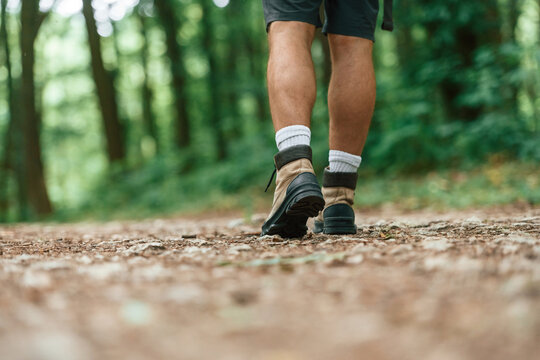 Close up rear view of tourist legs that is in summer forest - Powered by Adobe