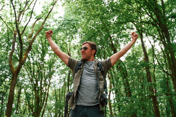 Enjoying the freedom, hands to the sides. Tourist in summer forest. Conception of exploration and leisure