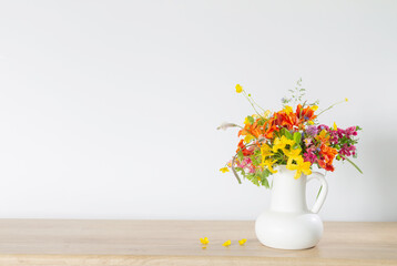 summer flowers in white jug on wooden table