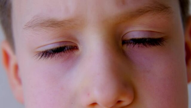 close-up of part of child's face, boy 8-10 years old Asian-European appearance, human eye looking seriously at the camera, the concept of surveillance, peeping, tracking