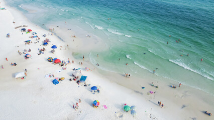 Colorful beach chairs, umbrellas and people swimming, relaxing laid-back, less crowded experience along white sandy beaches, turquoise water, gorgeous shade of blue Santa Rosa, Florida, USA
