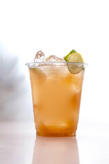 Iced peach cooler drink in plastic cup chilled.
