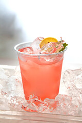 Pink rose lemonade placed on top of ice cubes with lemon slice and fresh mint.