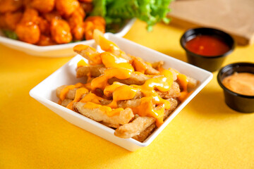 Poutine french fries potato chips topped with dynamite thousand island sauce served in plate.