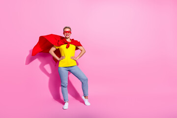 Full body photo of confident cheerful lady put arms waist wear red cape mask empty space isolated on pink color background