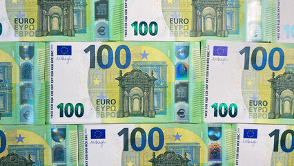 Top view of stacks of 100 euro bills. The single currency of the European Union. Background of money. Cash banknotes of one hundred euros. European currency. 