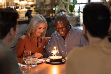 Senior couple celebrating a birthday with family in a restaurant