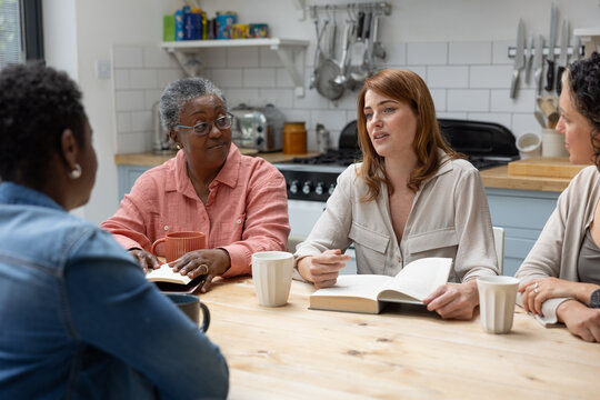 Group of women listening to young woman speaking in a book club