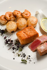 Assorted grilled seafood on a white plate.