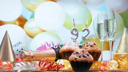 Happy birthday champagne background with number of candles  92. Beautiful congratulations copy space for anniversary..Festive decorations with a bottle of champagne in pastel colors.