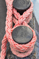 Thick rope and black mooring bollard. Detail of port. Yachting