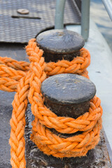 Fototapeta na wymiar Thick rope and black mooring bollard. Detail of port. Yachting