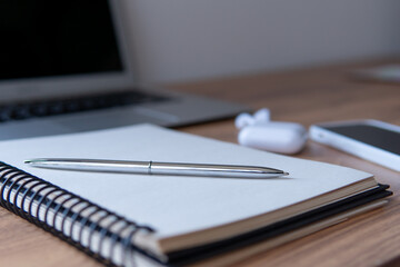 pen on a notepad close-up on the background of a laptop