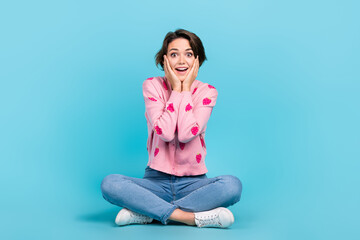 Full body photo of surprised astonished funky woman young age shocked reaction sitting floor unbelievable isolated on blue color background