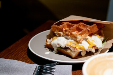 Belgian waffles with eggs and bacon. Breakfast in cafe