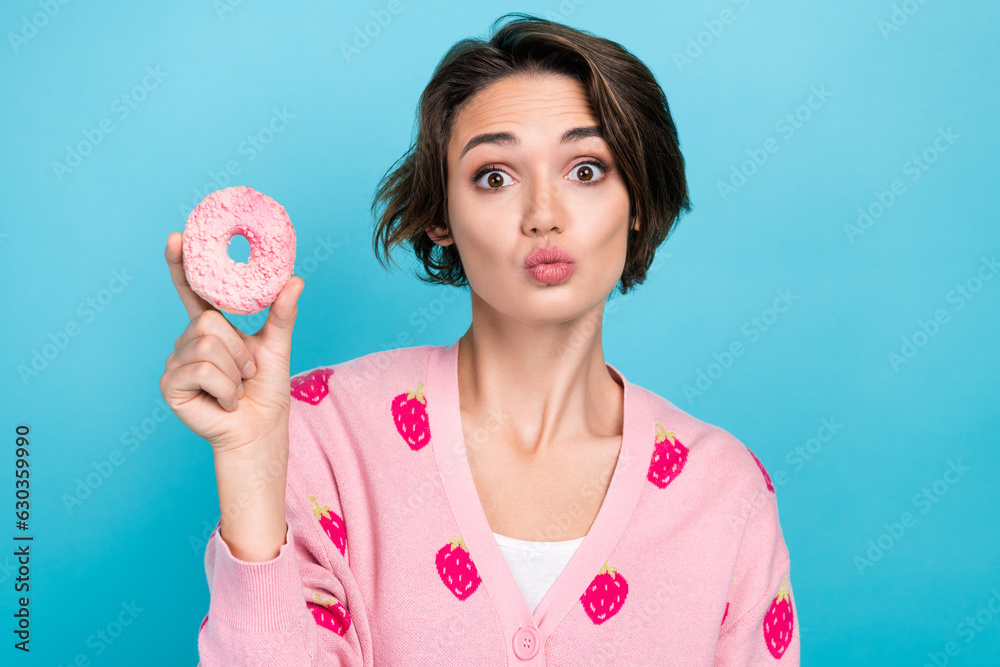 Wall mural Portrait of pretty nice person pouted lips kiss arm hold delicious glazed donut isolated on blue color background